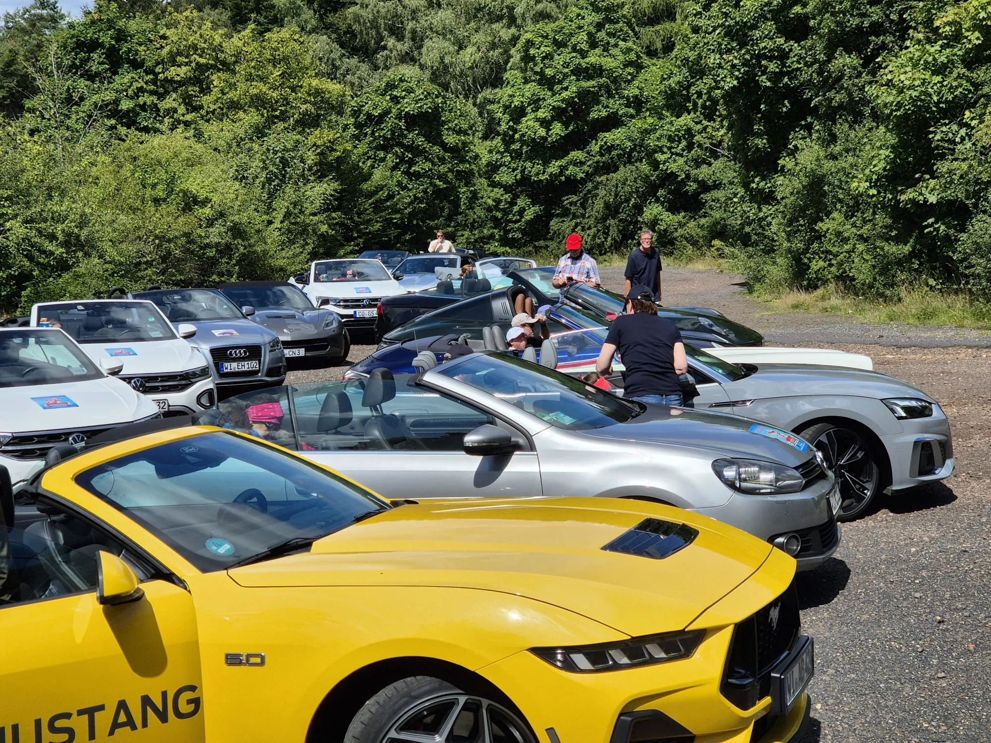 Reihe offener Cabrios – darunter Ford Mustang und Maserati – bereit zur Ausfahrt